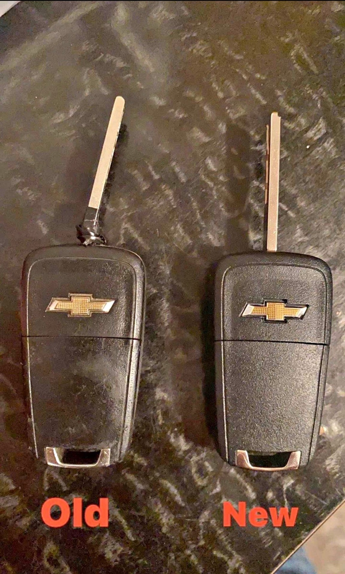 Old broken Chevrolet flip key beside a freshly cut replacement